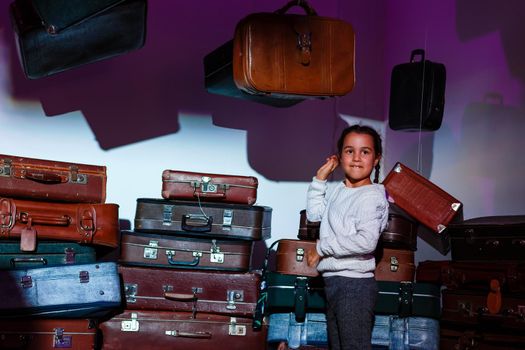 The little girl with old retro suitcases