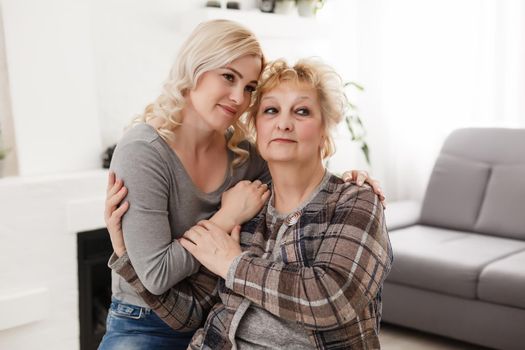 happy senior mother and adult daughter closeup portrait at home