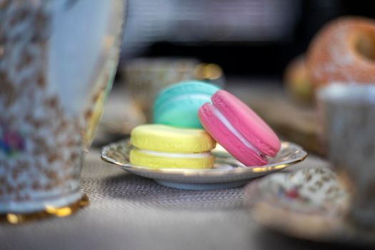 Traditional table with cup of tea and tea pot and colorful macaron lovely cozy table at home,Mother's Day tea setting with teapot, close up