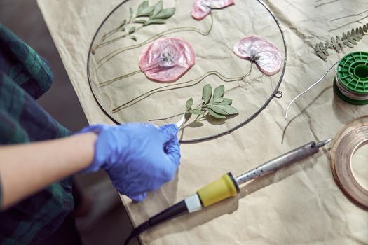 Confident female florist is working with dryed flowers in cozy flower shop