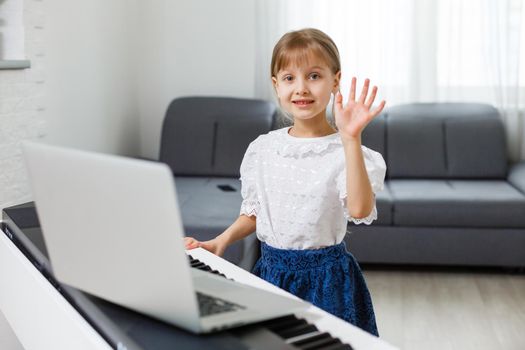 Little girl learning the piano during quarantine. Coronavirus concept.