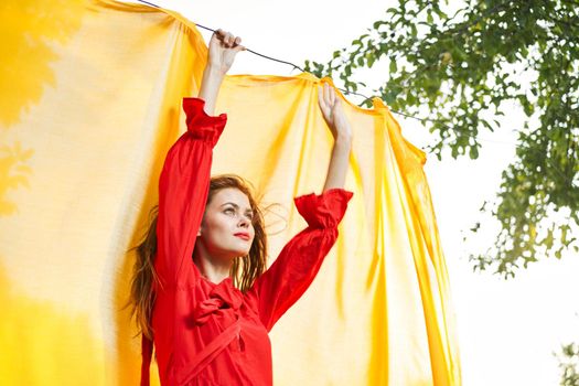 woman in red dress outdoors yellow bedspread. High quality photo