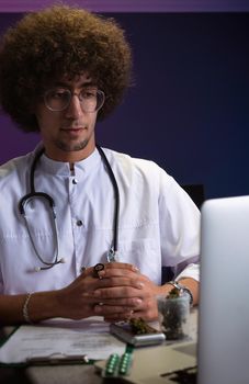 an Arab student with an Afro hairstyle in a doctor's suit is engaged in cannabis research