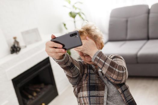 A crying elderly woman covering her face