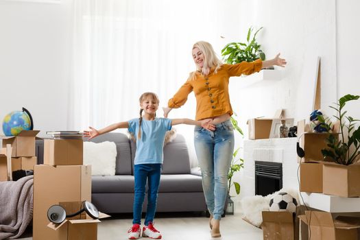 Little girl moving into new house, near cardboard box.