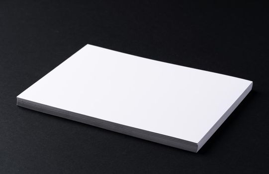 White blank business cards on dark black background, copy space