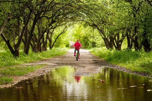 little girl riding bike in water puddle