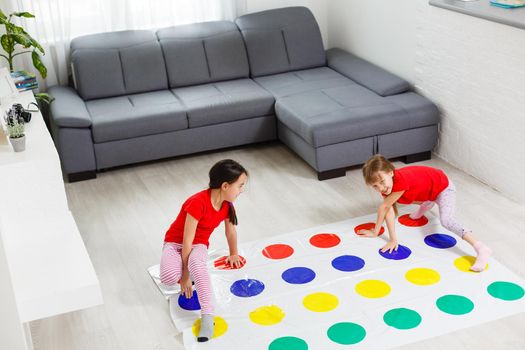 two little girls Having Fun Playing Game On Floor At Home. Siblings Friendship