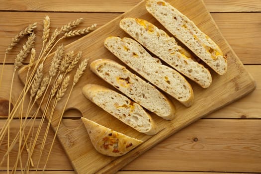 Fresh whole grain bread with cheese and ham. Natural food concept. Loaf of organic bread on wooden background.