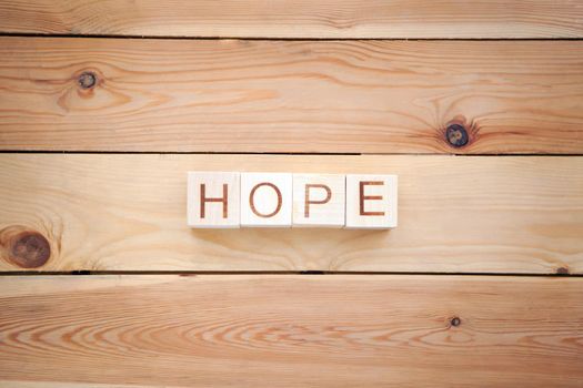 word HOPE at the wooden cubes on wooden backgroung - concept picture about hope and faith