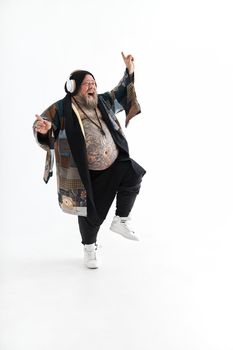 Fat stylish bearded tattoed caucasian man with big belly is posing and dancing wearing ethnic kimono