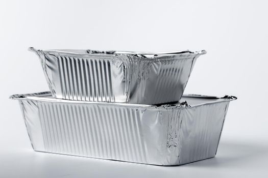 Foil food box with takeaway meal on white background close up