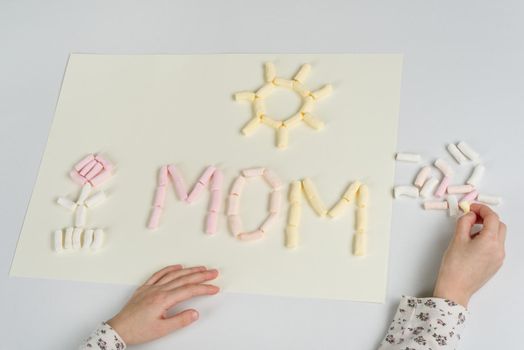 Mothers Day. A gift to the child mom, drawing an applique from marshmallow.