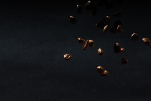 Several coffee beans isolated on black background with reflection. Culinary coffee background