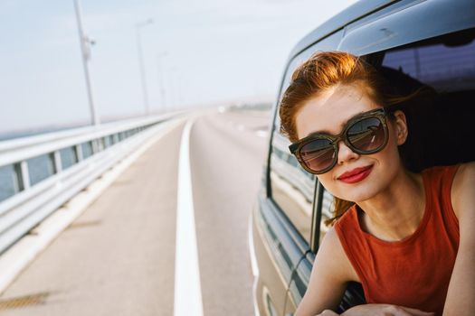 woman looking out of car window wearing sunglasses travel lifestyle. High quality photo