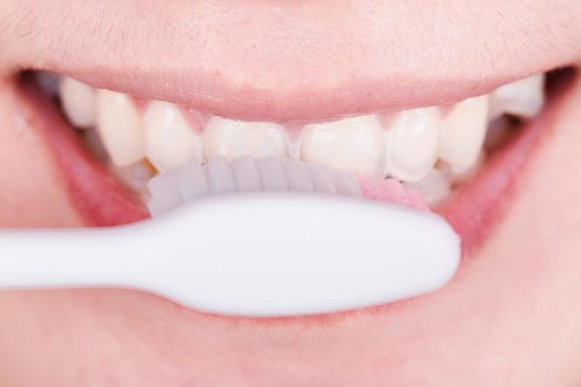 close up of mouth brushing teeth 