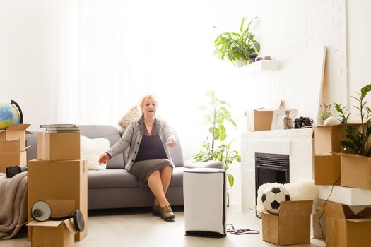 elderly woman next to an air purifier moving to a new apartment