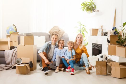 Happy family with cardboard boxes in new house at moving day.