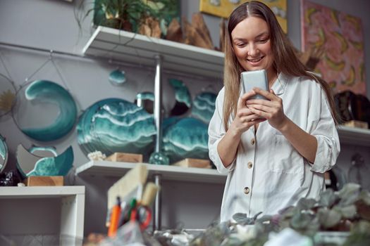 Young caucasian happy seller woman at botanic shop