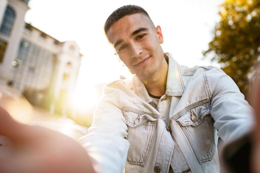 Portrait of young man taking a selfie while out on the city street, close up selfie