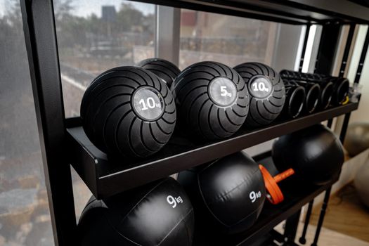 Balls and foam roller sport equipment in a gym on shelf