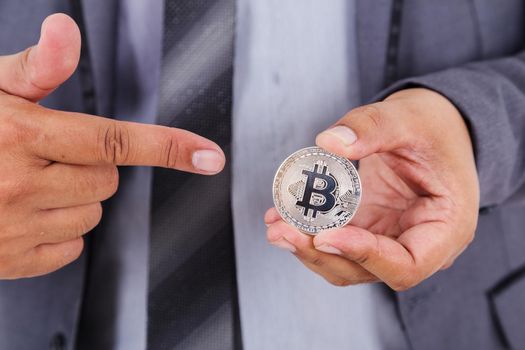 silver bitcoin in hand of business man with suit