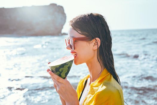 cheerful woman near the ocean with watermelon posing. High quality photo