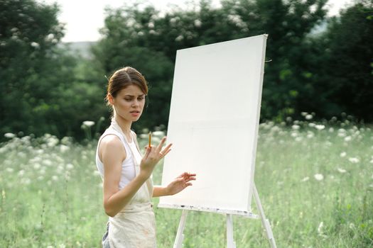 woman outdoors painting a picture creative art landscape. High quality photo