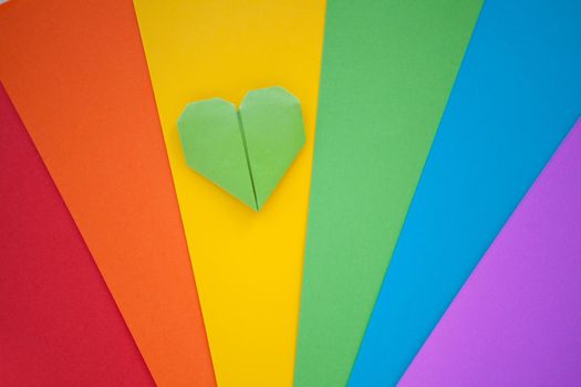origami hamdmade heart and Paper with lgbt colors as a background. Rainbow colors. Pride community. Love and freedom concept.