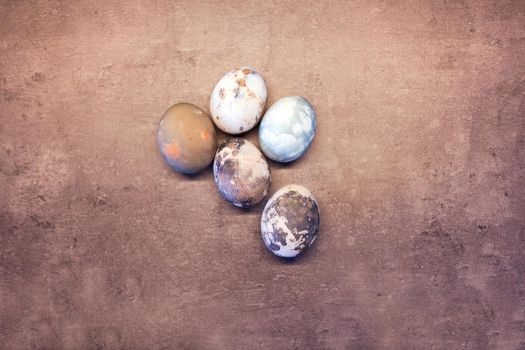 Happy Easter. Series of eggs with marble stone effect painted with natural grey concrete background with blank space for text. top view, flat lay