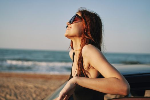 woman on the beach is with a car wearing sunglasses travel. High quality photo