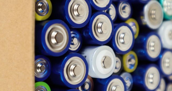 Background view of AAA AA batteries and rechargeable batteries. Choice of batteries. Energy supply and recycling concept. Textures of electrical elements packed close to each other