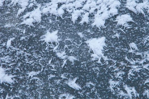 snow paintings on ice surface. frozen snowflakes - ice abstract textured background