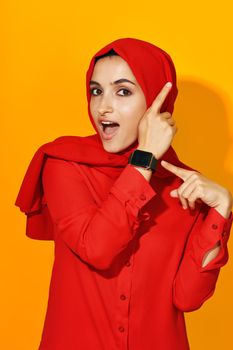 woman in red hijab with clock in hands technology emotions studio lifestyle. High quality photo