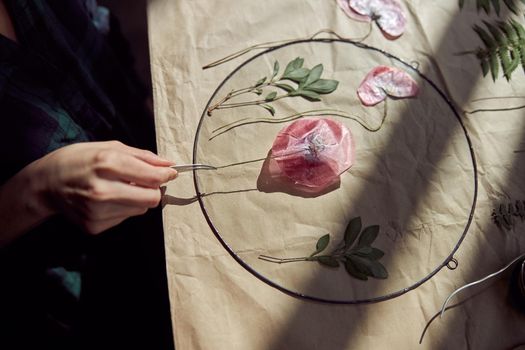 Confident female florist is working with dryed flowers in cozy flower shop