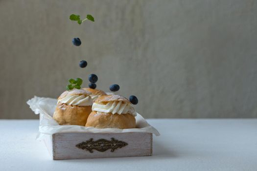 Fresh baked homemade buns with blackberries on the table for breakfast Baking traditional Swedish semla bread for Throve thursday. food concept