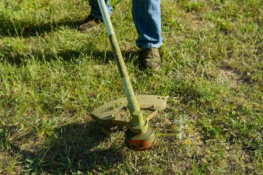 Man mowing grass on a rural lawn, close-up,