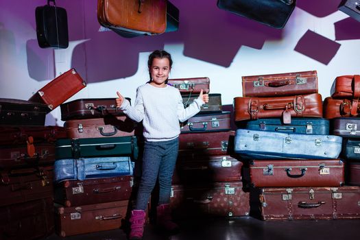 The little girl with old retro suitcases