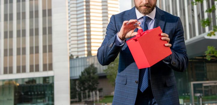 entrepreneur hold birthday gift. shopping concept. mens day. cropped businessman open box. sale and discount. business reward. be my valentine. boxing day. handsome man with present box.