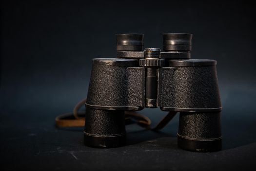 Vintage binocurars isolated on black background with reflection.