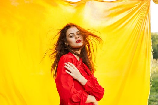 pretty woman in red dress outdoors nature yellow cloth. High quality photo