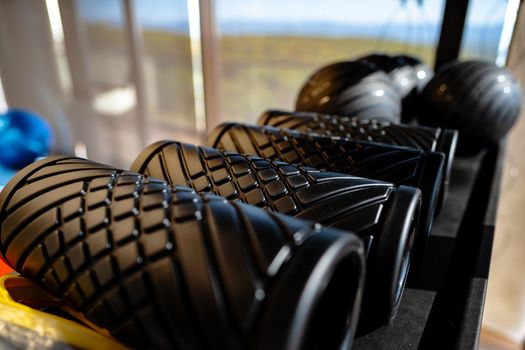 Balls and foam roller sport equipment in a gym on shelf