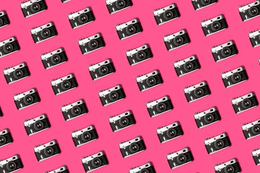 Retro camera isolated on bright pink background creative pattern. Pop art concept. Flat lay in minimal style