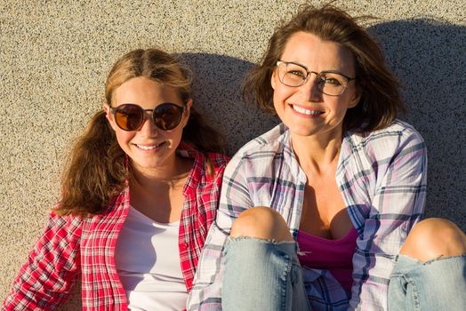 Portrait of mother аnd daughter relaxing outdoors