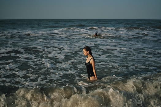 Cheerful woman black swimsuit ocean nature summer tan. High quality photo