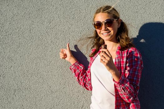 Portrait of beauty teen model girl holding chocolate bar and showing thumbs up. Thumb up energy and joy