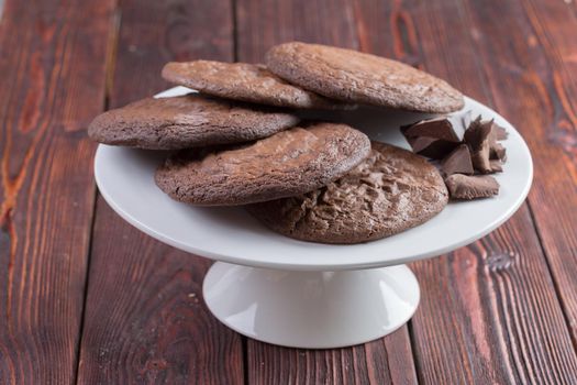 Chocolate oat cookies on green plate close up on wooden table