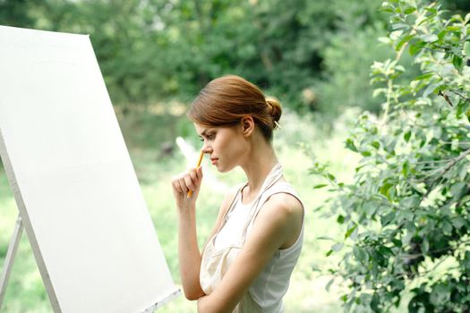 Cheerful woman artist nature easel creative art. High quality photo