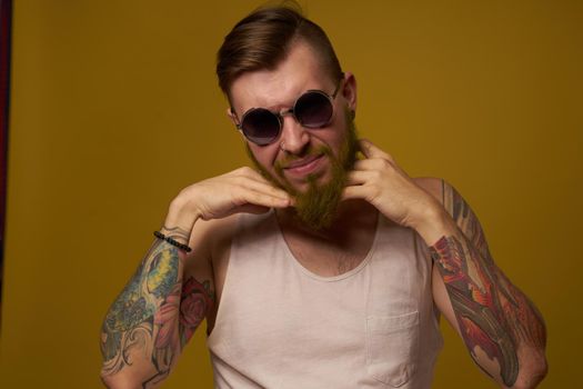 man in a white t-shirt tattoos on his arms fashion glasses modern style. High quality photo