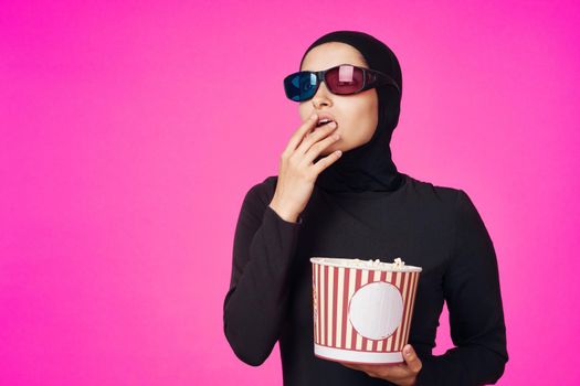 Muslim woman in 3D glasses popcorn entertainment movies model ethnicity. High quality photo